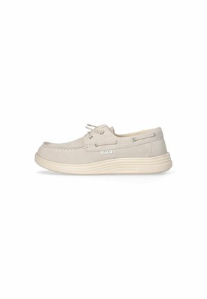 Zapatos de barco color beige claro con parte superior de tela texturizada, puntera redonda, cordones tonales y diseño minimalista. Suela de goma estriada para mayor tracción.