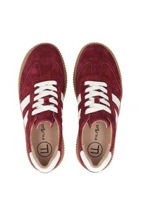 Czerwone zamszowe sneakersy z białymi paskami, z sznurowanym zapięciem i gumową podeszwą. Wnętrze jest beżowe z logo na wkładce.