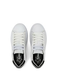 Sneakers bianchi in pelle con punta arrotondata, lacci piatti e interno nero. Presentano un logo e un design a forma di stella sulla linguetta.