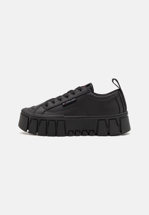 Czarny sneaker na platformie z grubą podeszwą, wiązaniem z przodu, przeszyciami i małym logo Tommy Jeans po boku na jednolitym tle.