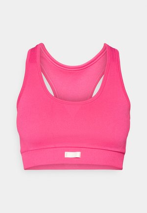 Helderroze naadloze sportbeha met brede banden en racerback ontwerp, voorzien van een klein wit merkteken op de voorband.