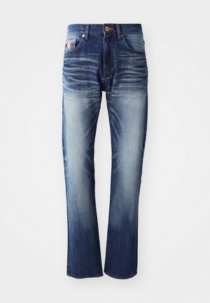 Jeans de denim en un degradado de azul oscuro a claro, con cinco bolsillos, cierre de botón y detalles de desgastado sutil en los muslos.