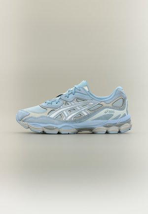 Zapatilla de running ASICS azul claro y gris con paneles de malla y ante, cierre de cordones y suela acolchada mostrada de lado sobre un fondo neutro.