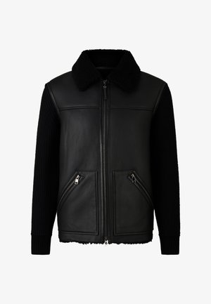 Czarna skórzana kurtka pilotka z kołnierzem z baranka, dzianinowymi, ściąganymi rękawami oraz dwoma przednimi kieszeniami na zamek. Teksturowane czarne akcenty.