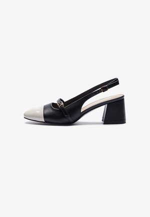Escarpin slingback noir et blanc avec talon bloc carré et petite bride avec boucle sur le dessus.