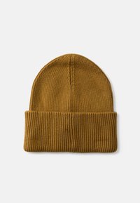 Bonnet en tricot de couleur moutarde chaude avec un revers côtelé, présentant une texture lisse et un design sans couture sur le dessus.