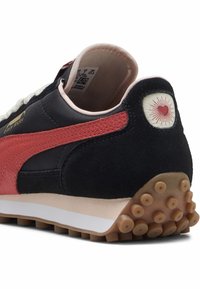 Czarno-czerwony sneaker z zamszowej i syntetycznej cholewki, retro design, zaokrąglona gumowa podeszwa z okrągłymi uchwytami oraz detal z logo serca.