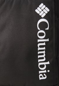 Zaino in tessuto nero con un grande logo bianco "Columbia" e un emblema geometrico, texture morbida e chiusura con zip.
