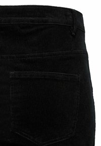 Pantaloni in corduroy neri con righe verticali, vita media e una tasca posteriore con patta a punta. La texture del tessuto resistente è visibile.