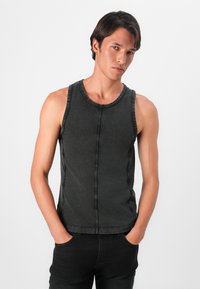 Top sin mangas de color gris oscuro con un escote redondo, con costuras en contraste y un diseño ajustado. Tejido de mezcla de algodón con una textura suave.