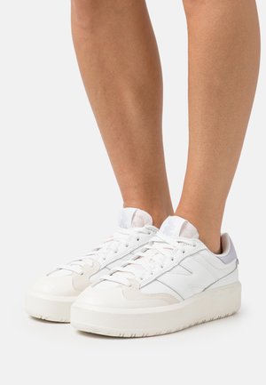 Zapatillas blancas con un diseño estratificado; parte superior de cuero suave, acentos texturizados y una suela gruesa y acolchada en color blanco roto.