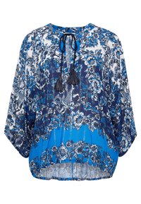 Blå och vit blommönstrad blus med lösa ärmar och framsidan med snörningar, som har en hög-låg fåll.