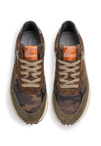 Braune Sneakers aus Mesh- und Wildledermaterialien, mit einem Camouflage-Muster, beigen Schnürsenkeln, Gummisohle und einem orangefarbenen Markenlogo auf der Zunge.