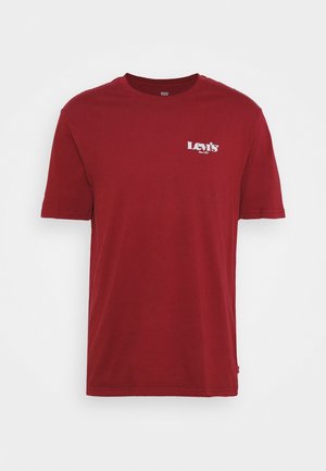 Plain red short-sleeve Levi’s T-shirt with white logo text on the left chest and a small red tag on the side seam.