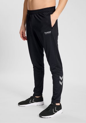 Zwarte sportbroeken met een slim fit, elastische tailleband, zijzakken en een reflecterend logo. Voorzien van grijze details op de onderbenen.