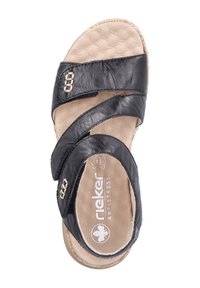 Sandale en cuir noir avec des brides croisées et une semelle intérieure rembourrée beige. Présente un logo sur la semelle intérieure et des coutures décoratives sur les brides.