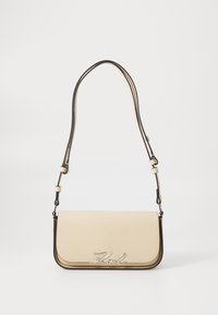 Borsa a tracolla in pelle beige con design a pattina, dettaglio logo argento e tracolla regolabile. Presenta bordature a contrasto e una superficie liscia.