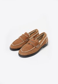 Mocasines de ante marrón con forro de piel, con acentos cosidos y suela de goma. Diseñados para la comodidad y el calor.