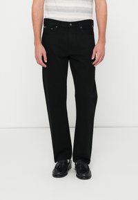 Jeans de mezclilla negra con un diseño de pierna recta, que cuentan con un cierre de botón, trabillas para cinturón y un estilo minimalista sin adornos.