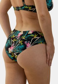 Bas de bikini floral avec un fond noir, présentant des motifs tropicaux vibrants en rose et turquoise, texture douce et taille mi-haute.