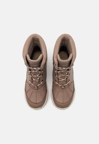 Brązowe wodoodporne buty z teksturowaną skórzaną cholewką, wyściełanym kołnierzem i metalowymi przelotkami, z kontrastowymi sznurowadłami i przeszytym wzorem na palcach.