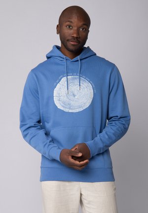 Blauwe hoodie met een cirkelvormige boomringgrafiek en tekst. Heeft een voorzak, een capuchon met trekkoord en ribgebreide manchetten. Zachte stoftextuur.