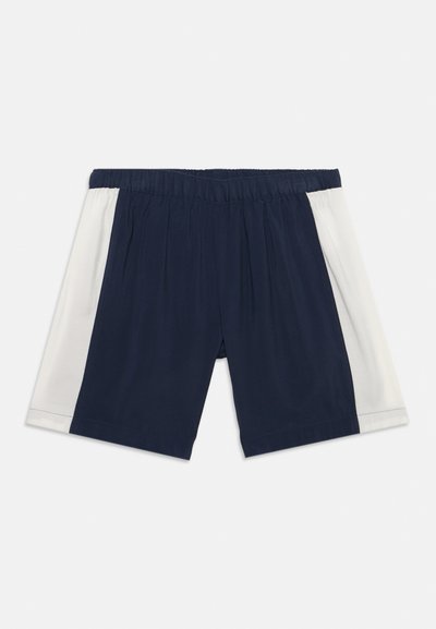 Σκούρο μπλε αθλητικό σορτς με ελαστική μέση και λευκές πλευρικές λωρίδες, απλωμένο επίπεδα σε λευκό φόντο.