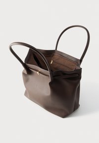 Καφέ τσάντα tote από δέρμα με δύο ανθεκτικές λαβές, υφή εξωτερικά και ευρύχωρο εσωτερικό με φερμουάρ στην τσέπη.