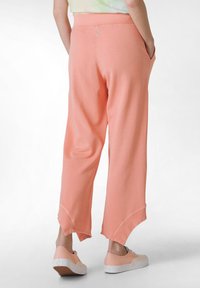 Helle rosa, lässige Sweatpants mit weitem Bein und rohem Saum, ausgestattet mit Seitentaschen und einem glatten, elastischen Bund.