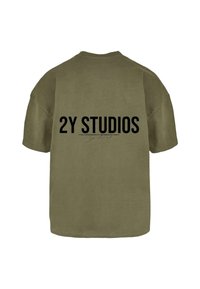 Alyvuogių žalios spalvos per didelė medvilninė marškinėlė, kurios nugarėlėje ryškiai juodu tekstu užrašyta "2Y STUDIOS" su mažesniu detalumu žemiau.