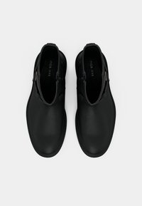 Černé kožené kotníkové boty s hladkou texturou, zaoblenou špičkou, bočním zipem a dekorativním akcentem na svrchní části.