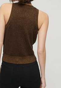 Top metallico marrone, senza maniche, con un orlo aderente, texture liscia e una leggera lucentezza, abbinato a jeans neri a vita alta.