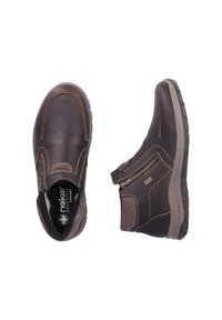 Bottines en cuir marron foncé avec une surface texturée, des coutures beige, une fermeture éclair sur le côté et une semelle en caoutchouc pour une meilleure adhérence et confort.