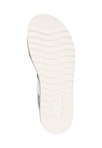 Semelle de sneaker blanche avec un motif de traction ondulé, en matériau caoutchouteux, de forme arrondie et avec un logo de marque en relief. Surface lisse et légèrement texturée.