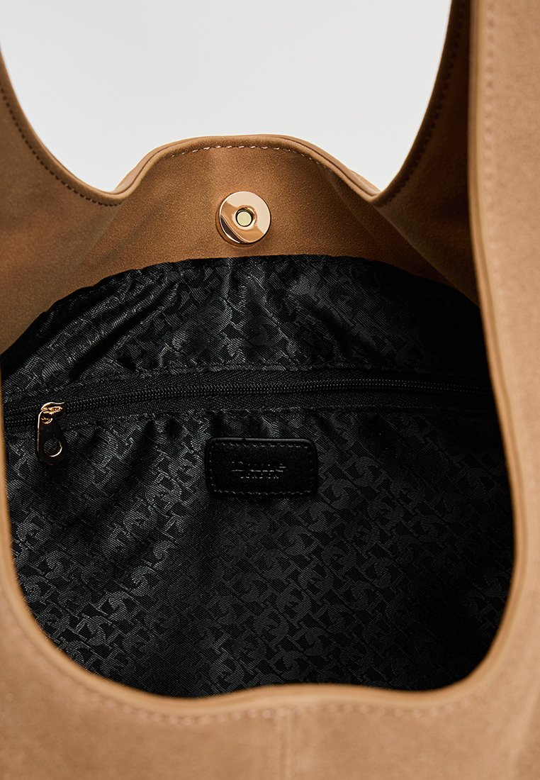 Beige Wildleder-Tote-Bag mit einem magnetischen Druckverschluss. Das Innere ist mit einem gemusterten schwarzen Futter ausgestattet und verfügt über eine Reißverschlusstasche für sichere Aufbewahrung.