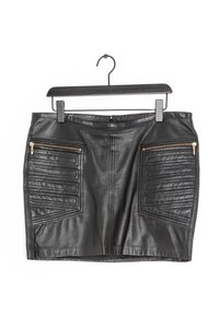Falda de cuero negra con forma ajustada, que presenta acentos de patchwork texturizado y dos bolsillos con cremallera y herrajes dorados.