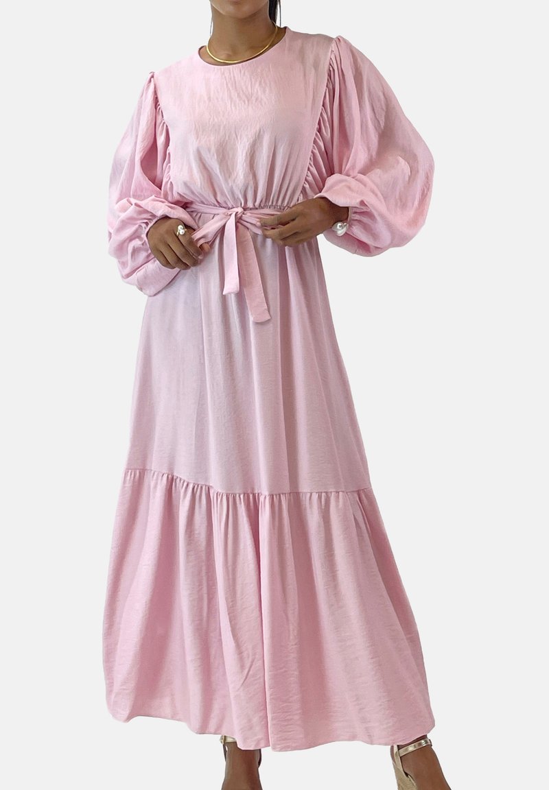 Vestido rosa de manga larga con mangas fruncidas, cintura entallada y falda de volantes. Tejido suave con textura lisa y cinturón a juego.