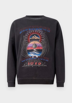 Svart sweatshirt med en grafisk design som har texten "BILLABONG WORLD TOUR 1973", berg och himmelska element i flera färger.