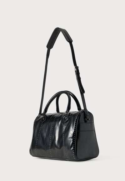 Μαύρη δερμάτινη τσάντα χειρός με γυαλιστερό φινίρισμα, που διαθέτει διπλές λαβές, αποσπώμενο ιμάντα ώμου και διακοσμητικά καρφιά κατά μήκος των πλευρών.