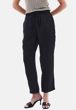 Zwarte, lichte, loszittende broek met een elastische tailleband en trekkoord, voorzien van zijzakken en een gladde textuur.