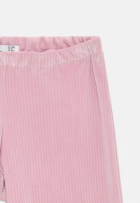 Lyserøde ribbede leggings i stof med elastisk talje. Blød tekstur med en behagelig pasform, designet til afslappet brug.