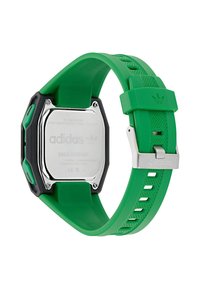 Montre numérique verte avec un bracelet en plastique, boîtier noir massif, dos en acier inoxydable et accents de marque. Résistante aux chocs.
