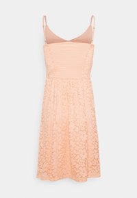 Robe en dentelle pêche avec bretelles ajustables, corsage froncé et jupe évasée; présente un motif floral complexe et une texture douce.