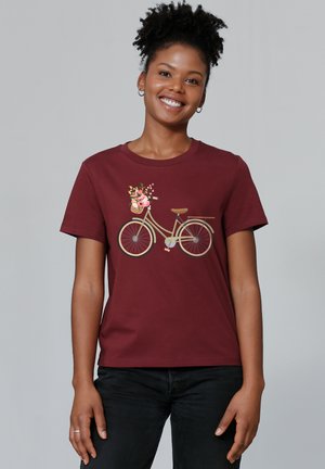 T-shirt en coton bordeaux avec un motif imprimé de bicyclette portant un panier de fleurs. Manches courtes et col rond, coupe décontractée.