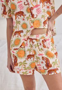 Button-up shirt and matching shorts with colorful sun, tiger, palm tree, and "fiesta then siesta" print on light fabric.