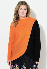 Oranssi ja musta kaksivärinen neulepaita, jossa on pyöreä kaula-aukko, ribbitekstuuri ja epäsymmetrinen muotoilu. Pitkät hihat, joissa on tiukat hihansuut.