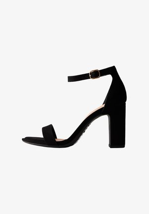 Schwarze Wildleder-Peeptoe-Sandalen mit einem breiten Blockabsatz, offenen Zehen und einem verstellbaren Knöchelriemen mit einer goldenen Schnalle.