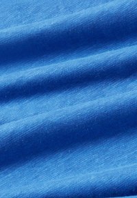 Tiefblauer Stoff mit einer weichen, glatten Textur, der subtile Farbvariationen und leichtes Wellen zeigt, was auf ein leichtes Material hindeutet.