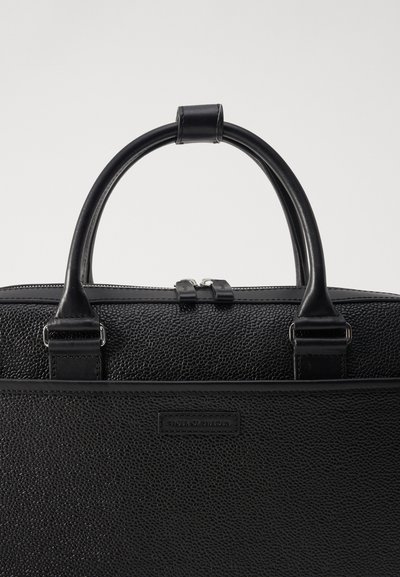 Black leather bag with textured surface, rounded handles, and silver zippers. Features a brand label on the front and reinforced stitching.