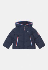 Giacca a soffietto blu navy con cappuccio, caratterizzata da un design trapuntato, doppia zip sul davanti, due tasche con zip e dettagli in rosso e bianco.